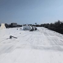 Flat commercial roof receiving a white protective coating