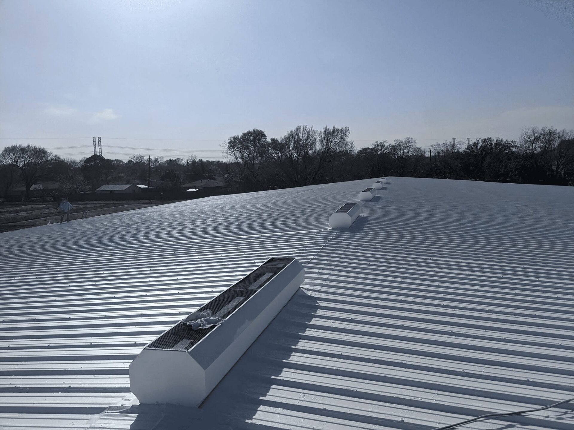 Commercial roofing crew in protective suits working on a roof